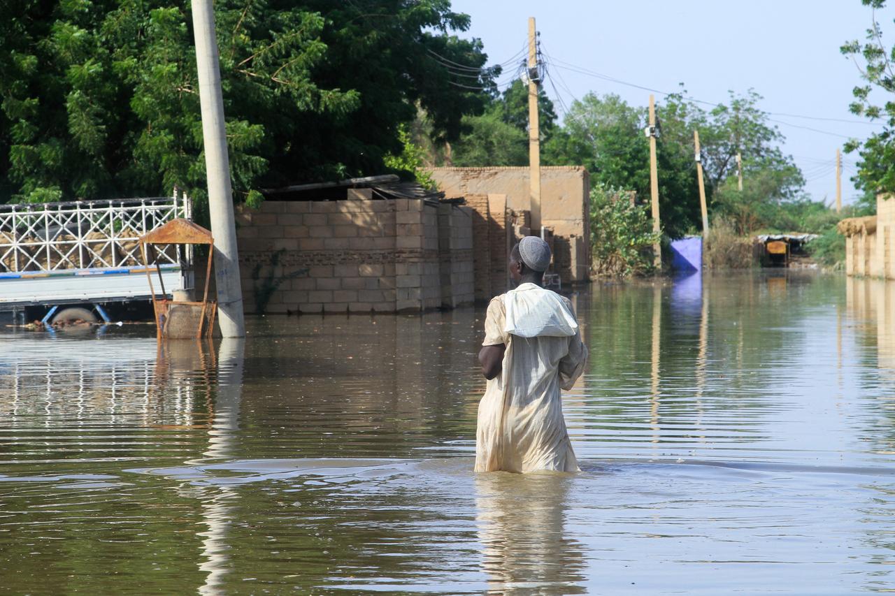 A resident wades in water, drowning a road due to the flooding of the Nile River in the Sudanese village of Wad Ramli north of Khartoum , Sudan , October 1, 2025. ( AFP Photo)