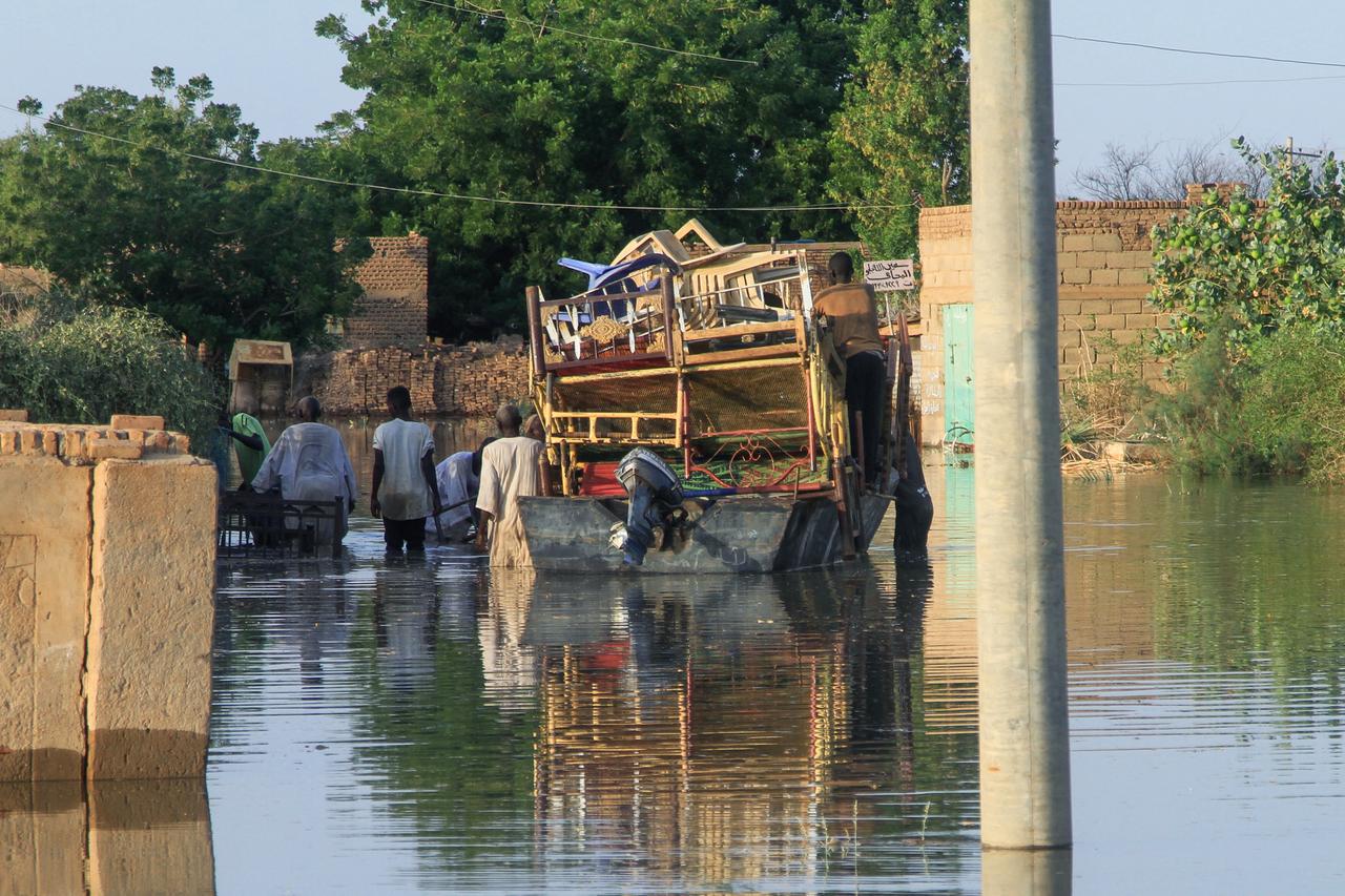 Residents use a barge to transport belongings as water drowns a road and the surrounding area due to the flooding of the Nile River in the Sudanese village of Wad Ramli, north of Khartoum, Sudan, October 1, 2025. (AFP Photo )