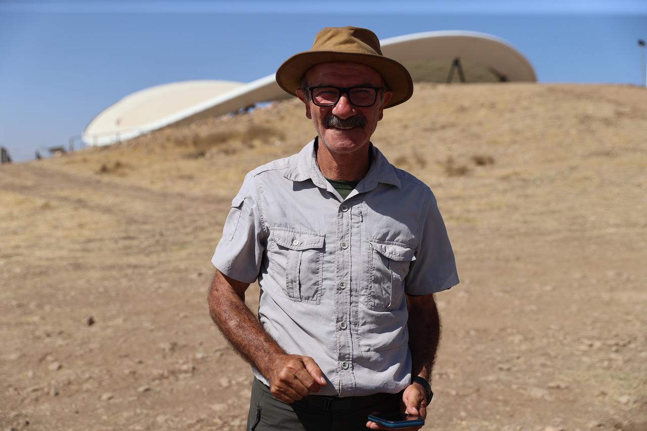 Professor Necmi Karul leading the excavation works stands near the protective roof covering Gobeklitepe’s Neolithic enclosures in Sanliurfa, Türkiye, Oct. 8, 2025. (AA Photo)