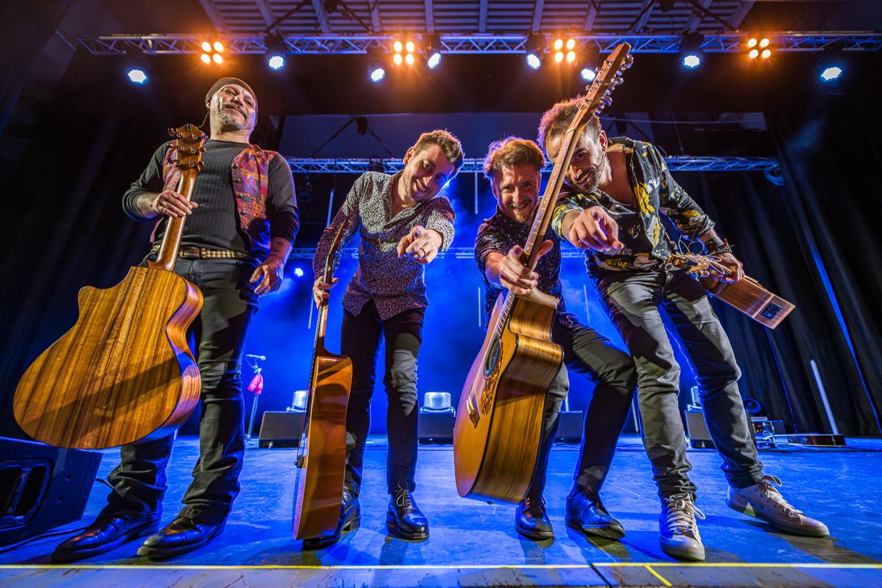 Members of the Italian guitar quartet 40 Fingers perform on stage during a live concert, showcasing their dynamic fingerstyle technique. (Photo via 40fingersguitarquartet.com)