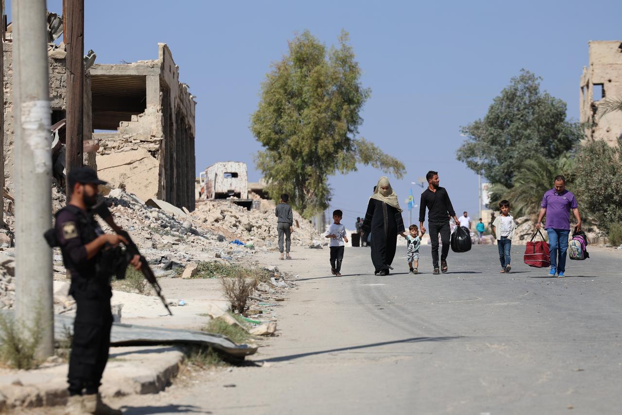 Suriye'nin Halep kentindeki Eşrefiye ve Şeyh Maksud'da Suriye güvenlik güçleri ile QSD arasında çıkan çatışmaların ardından yoğunlaşan silah sesleri nedeniyle yaygın paniğe kapılan siviller güvenlik arayışıyla bölgeyi terk ediyor, 7 Ekim 2025. (AA Fotoğraf)