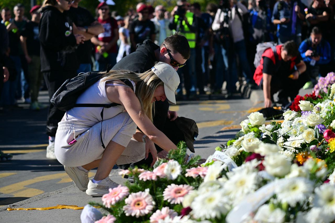 A woman reacts as mourners lay flowers outside the station during a gathering marking the first anniversary of the Novi Sad railway station tragedy, in Novi Sad, on November 1, 2025. (AFP Photo)