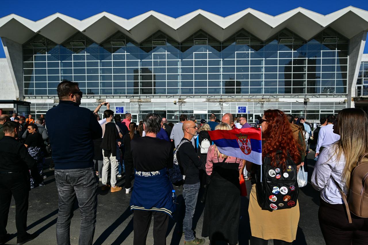 An attendee carries a Serbian flag as she joins mourners outside the station ahead of a gathering marking the first anniversary of the Novi Sad railway station tragedy, in Novi Sad, on November 1, 2025. (AFP Photo)