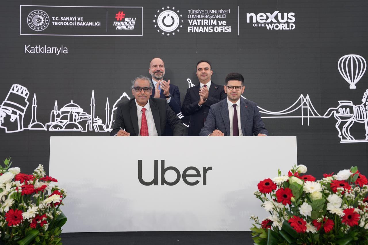 Investment Office President Burak Daglioglu (right) and Uber Head of Business Development Madhu Kannan (left) sign a memorandum of understanding to support Uber’s operations in Türkiye, witnessed by Uber CEO Dara Khosrowshahi (back left) and Industry and Technology Minister Mehmet Fatih Kacir (back right), in Istanbul, Türkiye, October 31, 2025. (AA Photo)