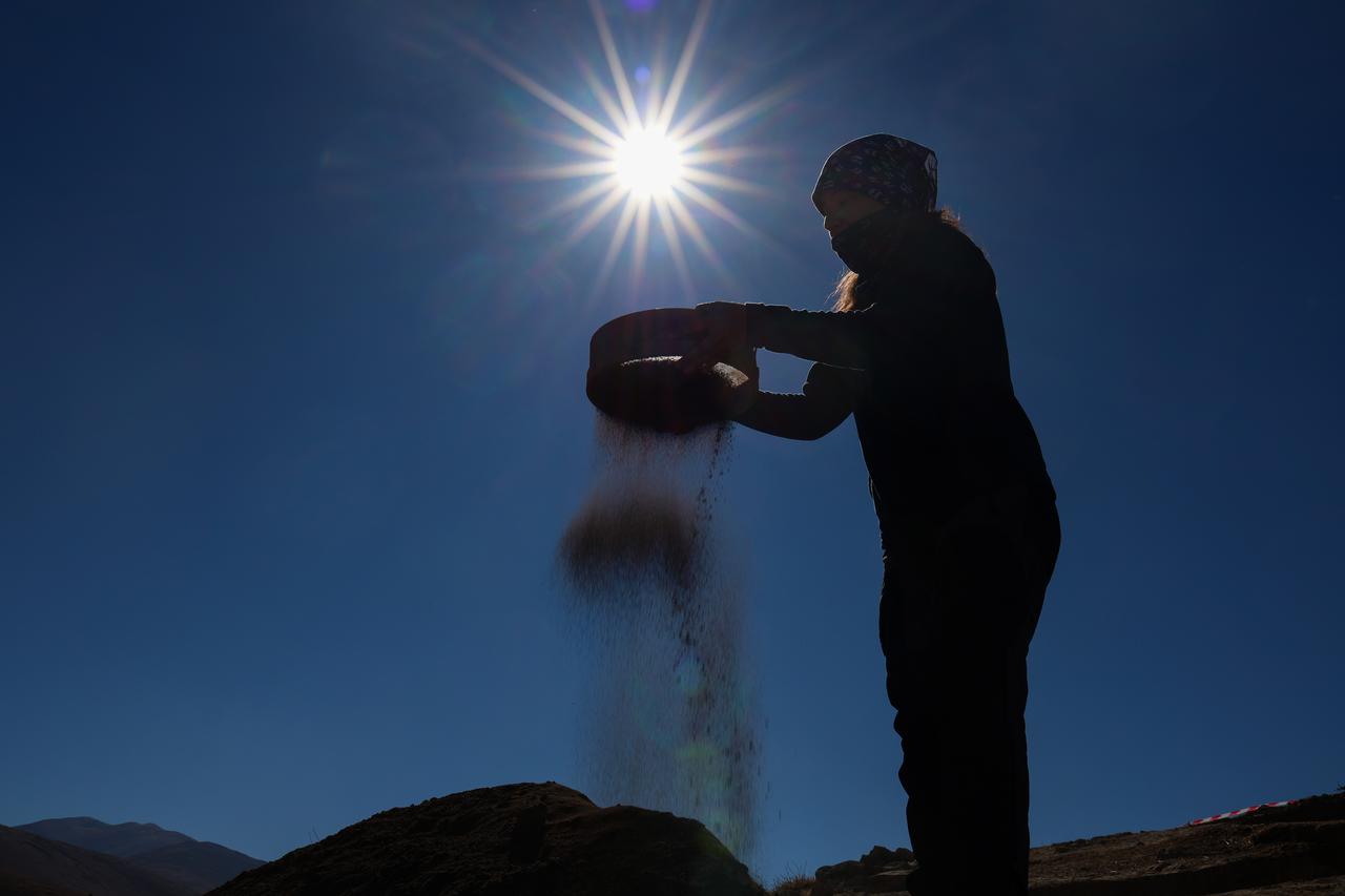 A member of the excavation team sifts soil under the strong autumn sun at Iremir Hoyuk in Gurpinar, Van, eastern Türkiye, Nov. 10, 2025. (AA Photo)