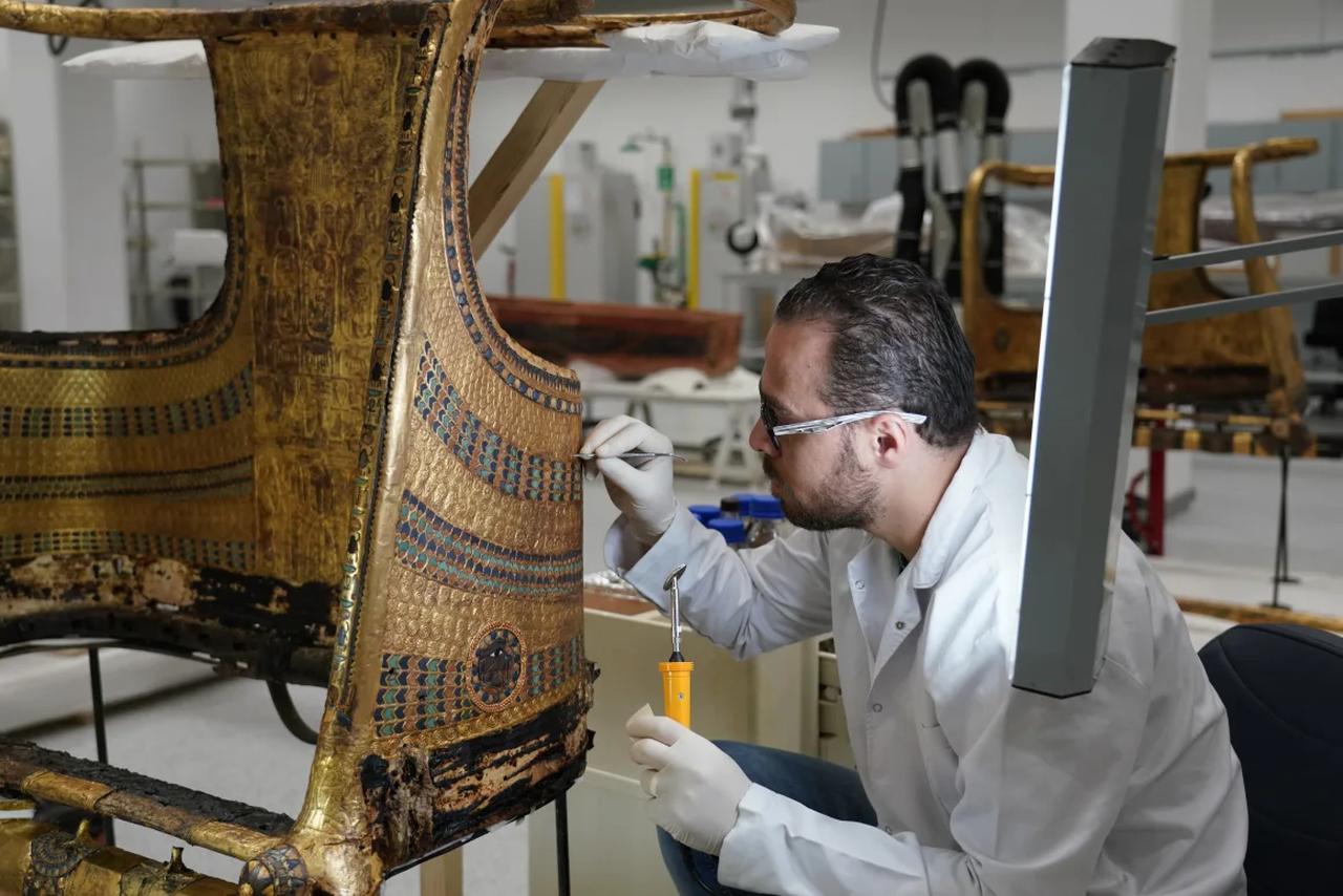Rami Magdy works on the restoration of a chariot from Tutankhamun's tomb at the Wood Laboratory in the Grand Egyptian Museum's conservation center. (Photo via Dana Smillie/CNN)