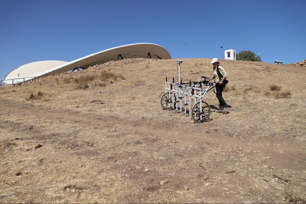 A researcher pushes a georadar cart during subsurface scanning near the monumental enclosures of Gobeklitepe in Sanliurfa, Türkiye, Oct. 8, 2025. (AA Photo)