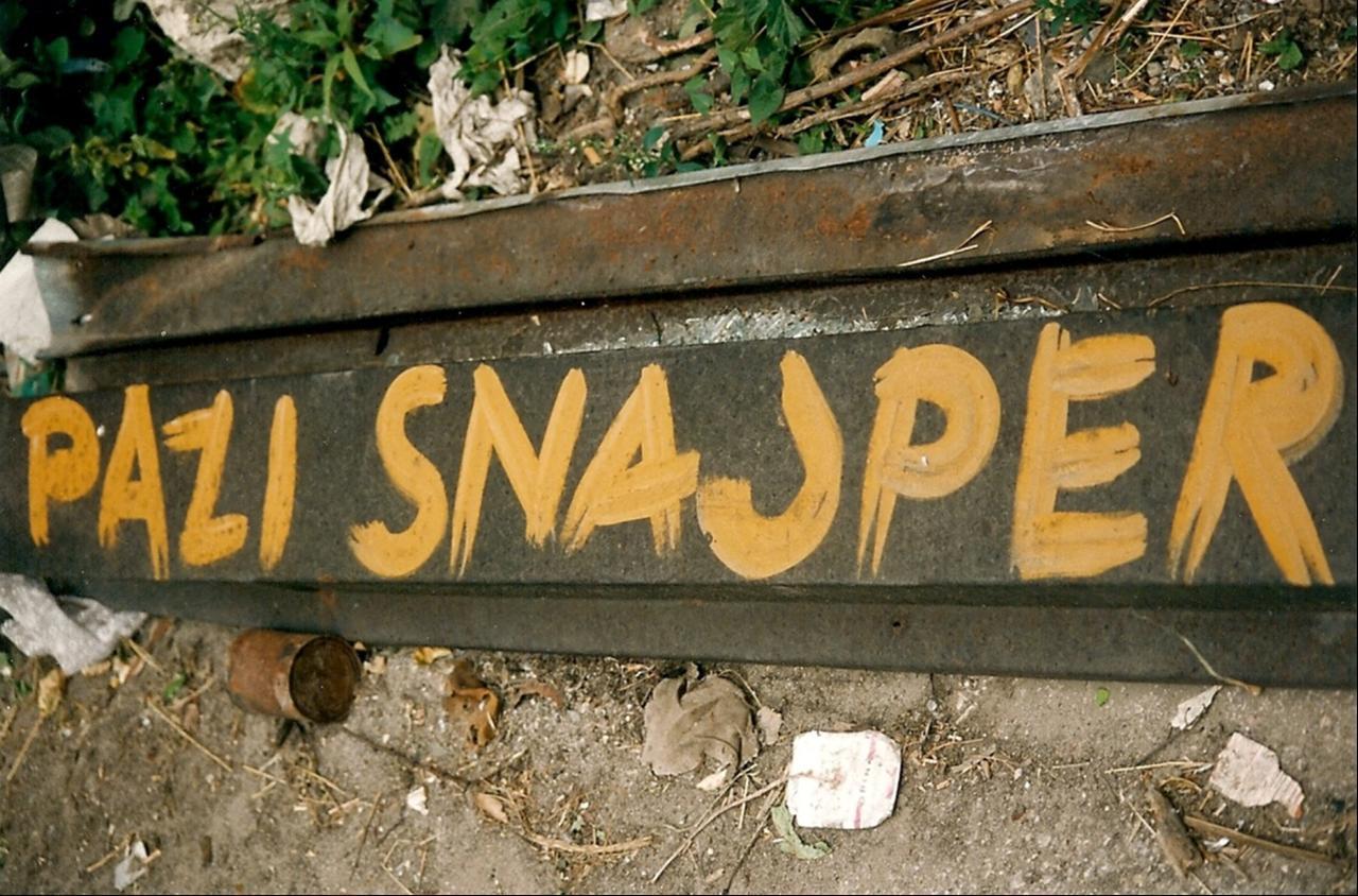 Hand-painted warning sign: "Watch out – Sniper". (Photo via Wikimedia/ By Paalso)