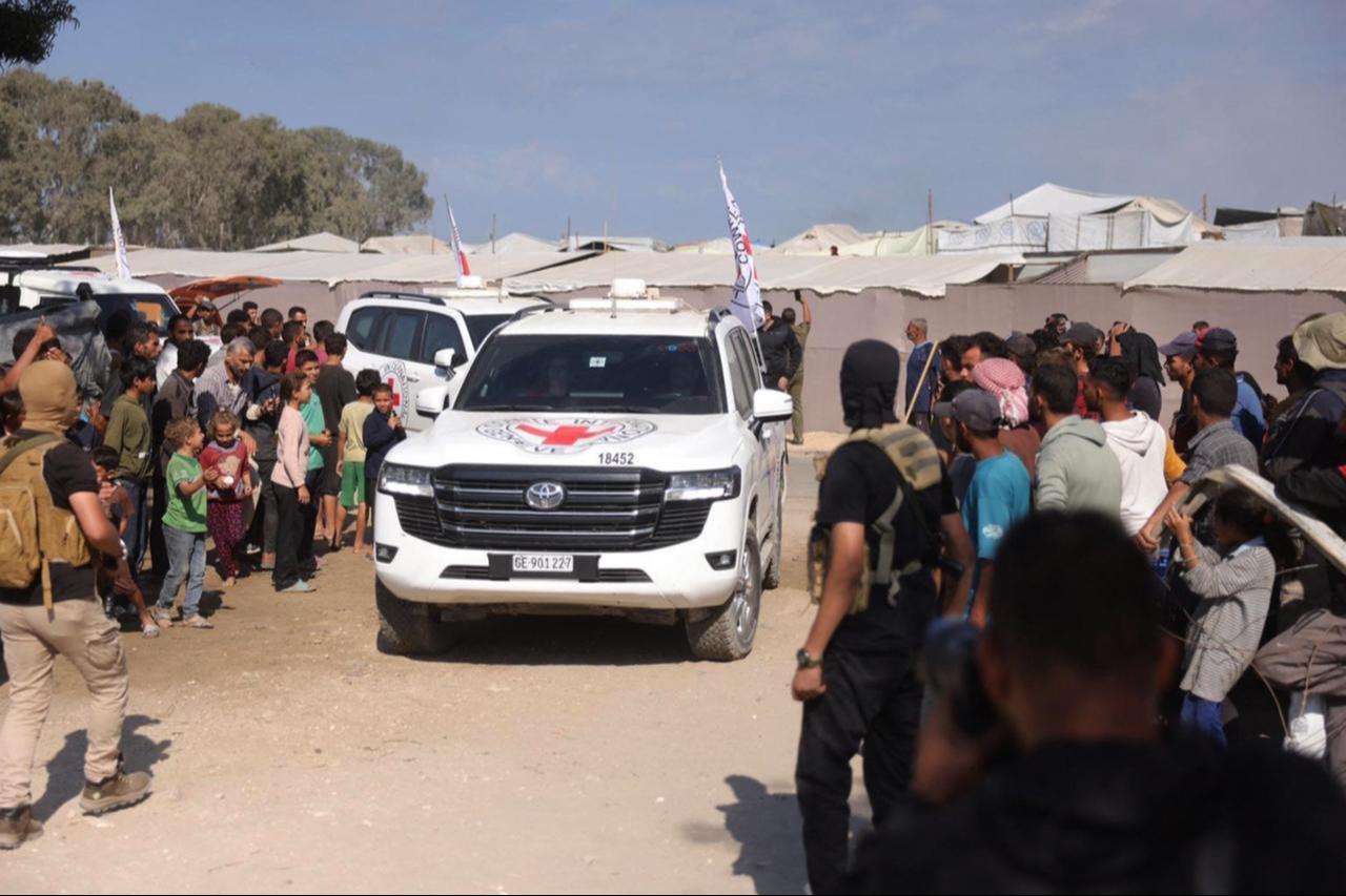 Palestinians gather on sides of the road as International Red Cross vehicles arrive to transport second batch of released Israeli hostages, south of Deir al-Balah in central Gaza Strip, on Oct. 13, 2025. (AFP Photo)