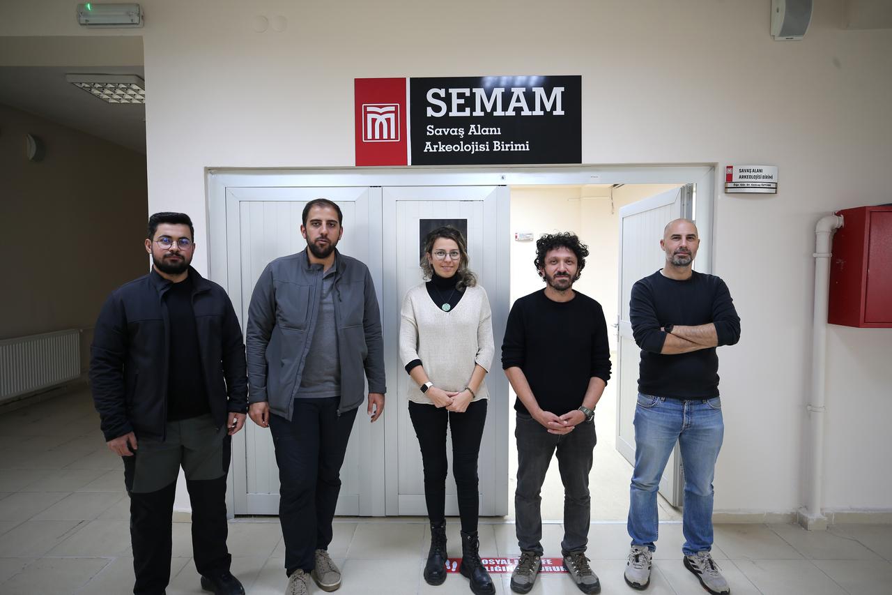 Researchers from the Battlefield Archaeology Unit of Mus Alparslan University pose for a photo in front of their lab in Mus, eastern Türkiye, Nov. 13, 2025. (AA Photo)