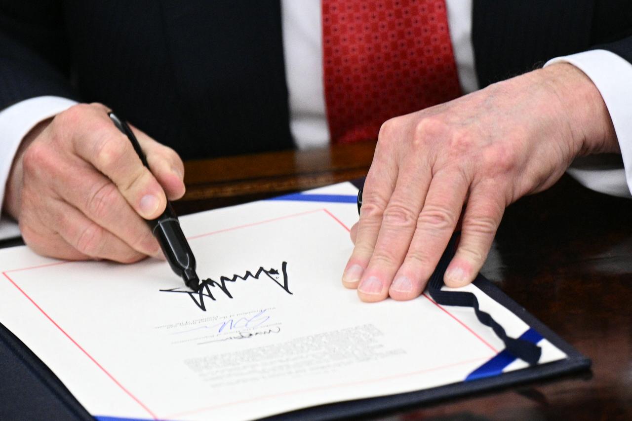 US President Donald Trump signs the bill package to re-open the federal government in the Oval Office of the White House in Washington, DC, November 12, 2025. (AFP Photo)