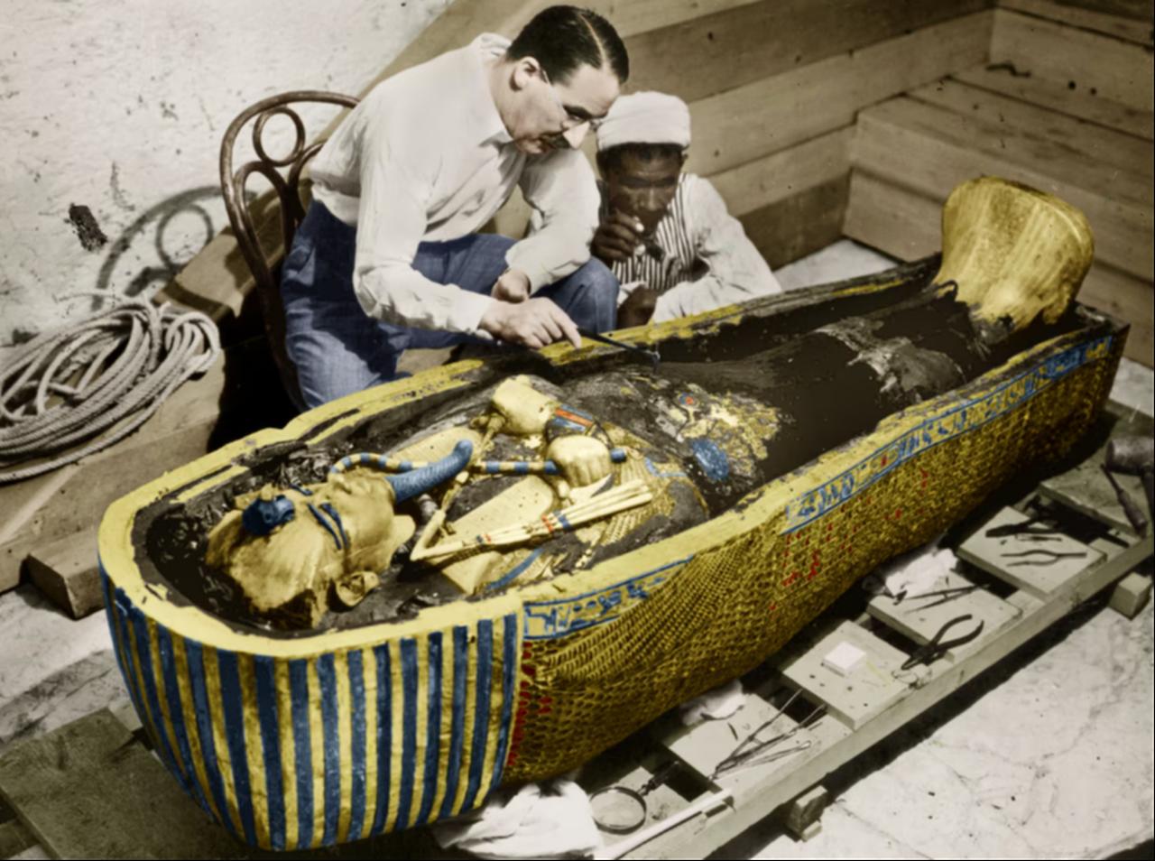 British archaeologist Howard Carter (left) examines King Tut's sarcophagus in 1922 (tinted photo). (Photo by Harry Burton/Apic)