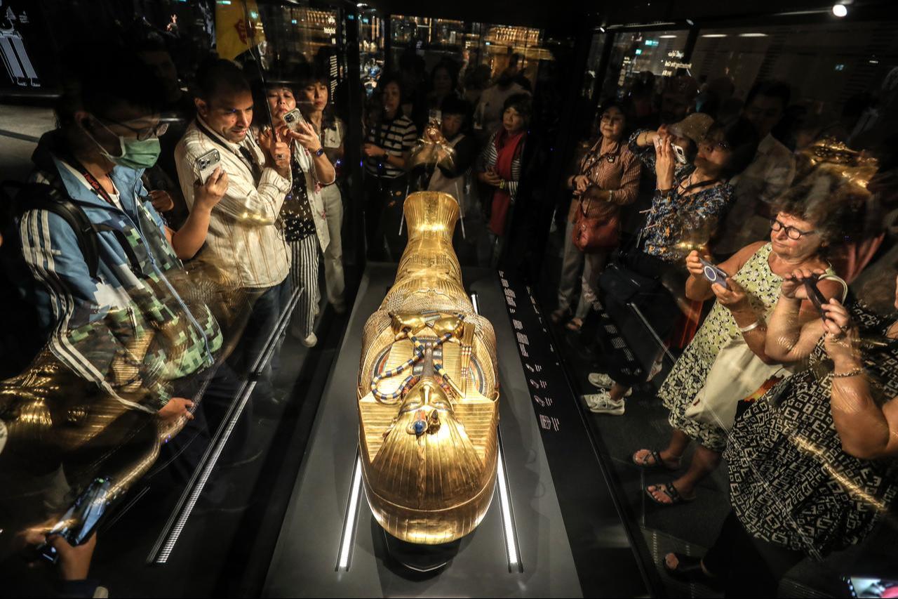 Visitors look at the golden coffin of Tutankhamun, the famous pharaoh of ancient Egypt, on display at the Grand Egyptian Museum, which sheds light on thousands of years of Egyptian history and houses hundreds of historical artifacts near the Giza Pyramids, in Giza, Egypt, Nov. 4, 2025. (AA Photo)