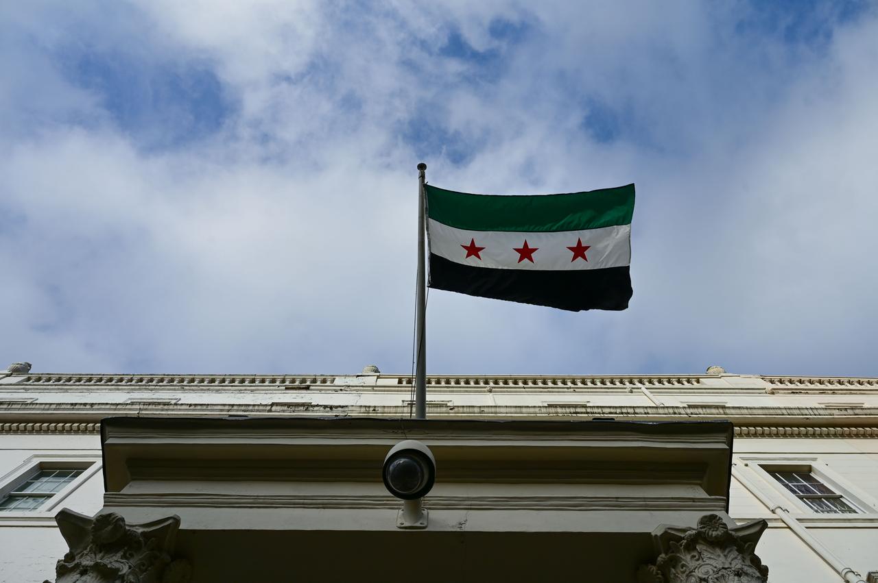 Syrian Foreign Minister  Asaad al-Shaibani raises the flag of the Syrian Arab Republic at the embassy building in London, which reopened after being closed since 2013, during his official visit to the United Kingdom, on Nov. 13, 2025. (AA Photo)