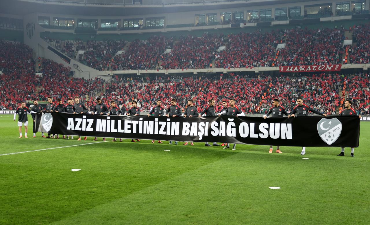 Turkish national football players take the field with a banner reading "Condolences to our noble nation" in tribute to Turkish soldiers who were martyred in a military cargo plane crash on the Azerbaijan-Georgia border as they enter the pitch for warming up ahead of the 2026 FIFA World Cup UEFA Qualifiers Group E football match between Türkiye and Bulgaria in Bursa, Turkiye, on Nov. 15, 2025. (AA Photo)