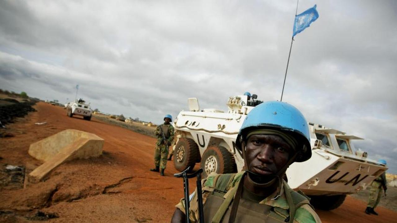 A United Nations peacekeeper stands guard as UN armored vehicles patrol in Abyei, Sudan. (Photo via un.org)