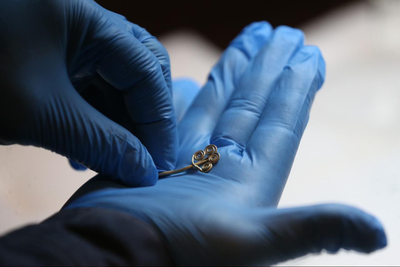 The gold spiral brooch uncovered at Troy being studied during conservation procedures at the Troy Museum, Canakkale, Türkiye, Nov. 17, 2025. (AA Photo)