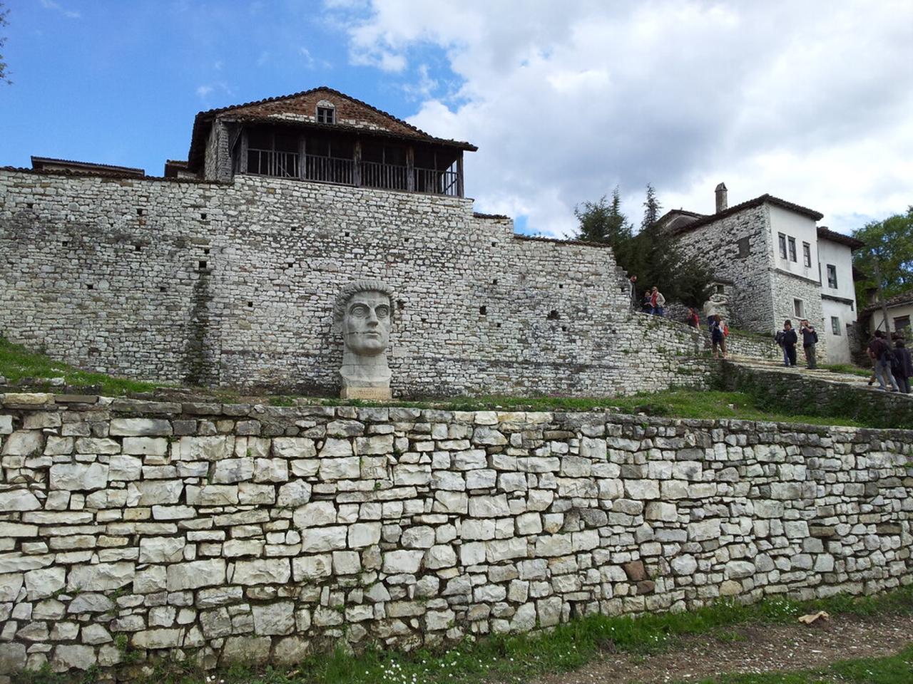 Ziyaretçiler, Arnavutluk'ta UNESCO Dünya Mirası Listesi'nde yer alan Berat Tarihi Merkezi'nin müstahkem taş duvarları boyunca yürüyor ve alt teraslara bakan geleneksel Osmanlı dönemi evleri var, 21 Nisan 2012. (Fotoğraf: Nikelina Bineri)
