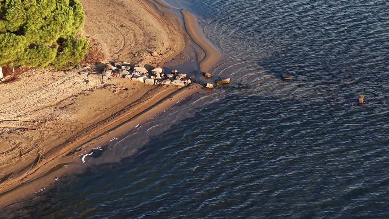 Partially submerged stone structures become visible as the sea recedes on the Duzler coastline in Erdek, Balikesir, northwest Türkiye, Nov. 17, 2025. (IHA Photo)