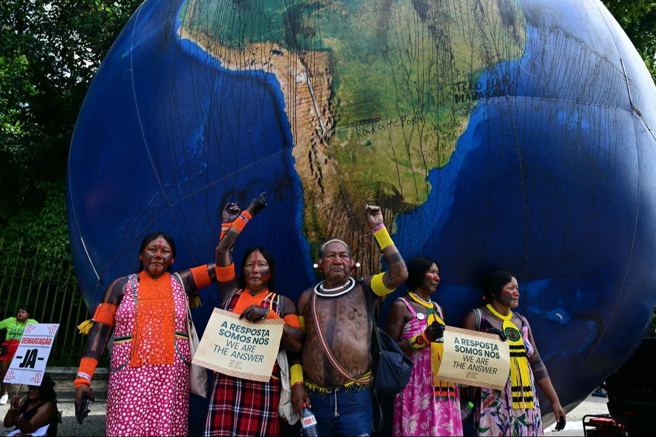 Indigenous people pose next to a giant inflatable globe during the "Indigenous People Global March" at the COP30 UN Climate Change Conference in Belem, Para state, Brazil, November 17, 2025. (AFP Photo)