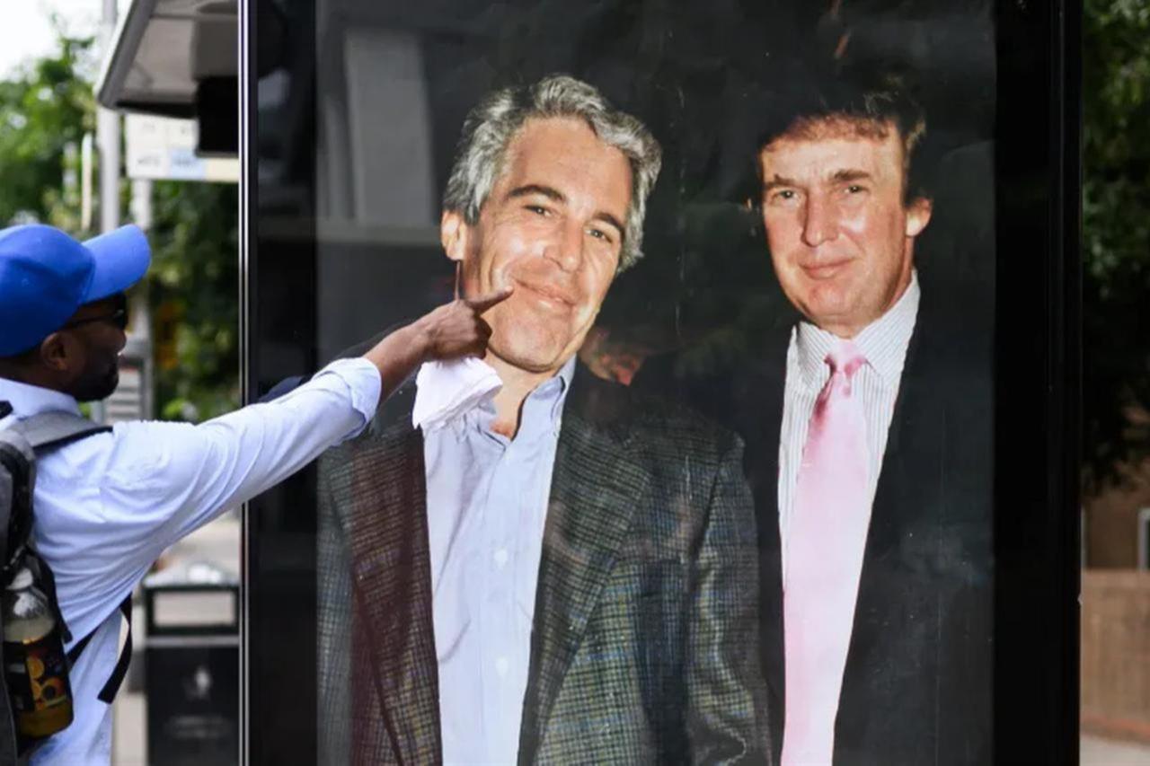 A man gestures to a photograph of US President Donald Trump and convicted child sex offender Jeffrey Epstein after it is unofficially installed in a bus shelter in London, England, July 17, 2025. (AFP Photo)