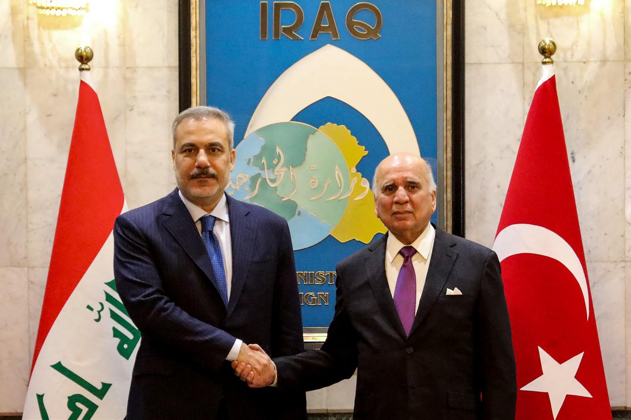 Turkish Foreign Minister Hakan Fidan (L) shakes hands as he is greeted by Iraqi Foreign Minister Fuad Hussein upon his arrival for an official visit to Baghdad on Nov. 2, 2025. (AFP Photo)