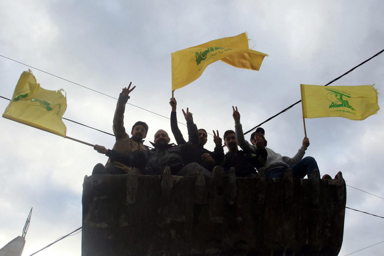 Men wave the flag of Hezbollah as they arrive in the southern Lebanese city of Nabatieh, November 27, 2024. (AFP Photo)