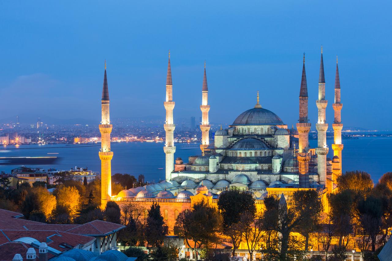 Aerial night view of the Blue Mosque in Istanbul, with the Bosphorus in the background. (Adobe Stock Photo)