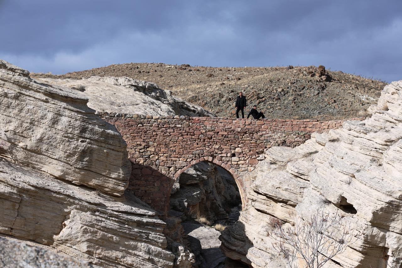 Visitors walk along the precariously narrow and elevated Seytan Koprusu, once used to carry water pipes across the deep valley in Sille, near Konya, Türkiye, Nov. 22, 2025. (IHA Photo)