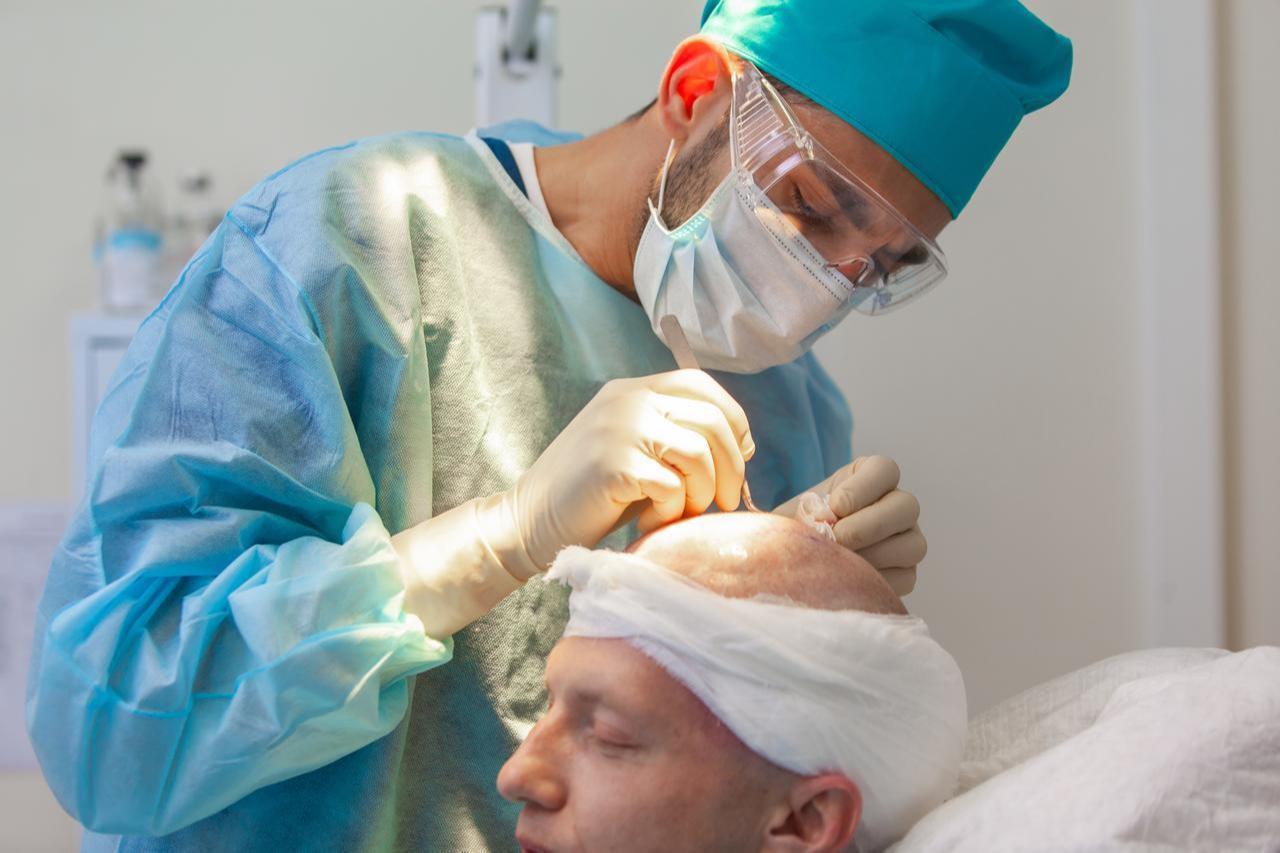 A surgeon performs a hair transplant procedure at a specialized clinic. (Adobe Stock Photo)