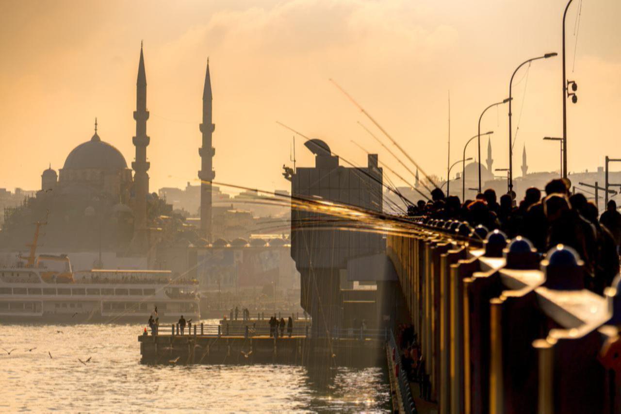 File photo shows fishermen casting their lines at sunset from Galata Bridge in Istanbul, Türkiye. (Adobe Stock Photo)