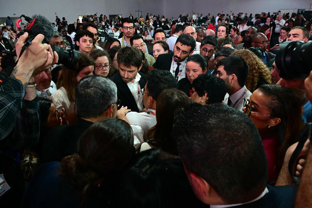 Çeşitli ülkelerden müzakereciler, 22 Kasım 2025'te Brezilya'nın Para eyaletinin Belem kentinde düzenlenen COP30 BM İklim Değişikliği Konferansı'nda genel kurul oturumu kesintiye uğradıktan sonra COP30 başkanlığının temsilcileriyle konuşuyor. (AFP Fotoğrafı)