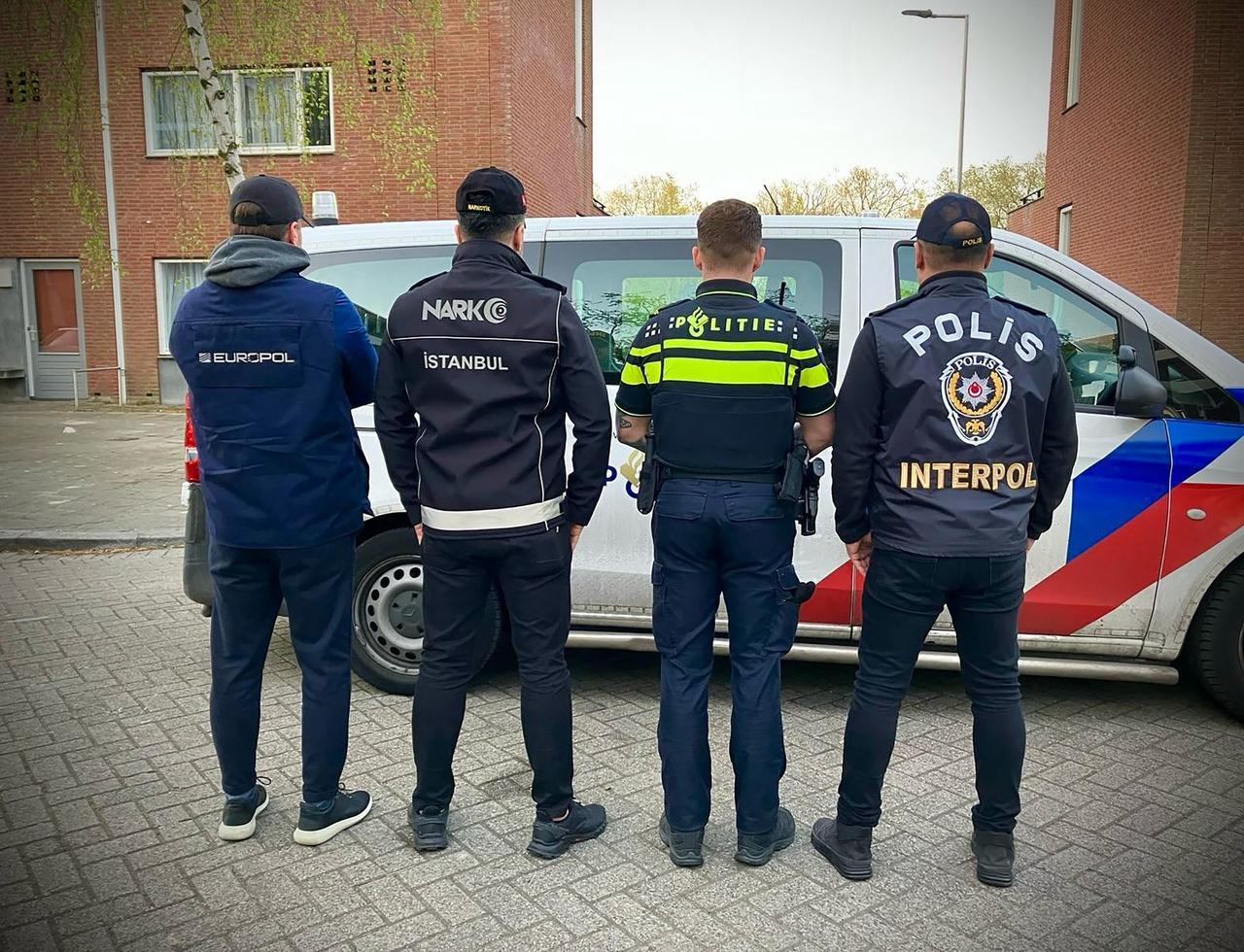 Officers from Europol, the Istanbul Police Counter Narcotics Department, the Dutch police, and the Turkish division of Interpol standing beside a police vehicle in the Netherlands. April, 15, 2025. (AFP Photo)