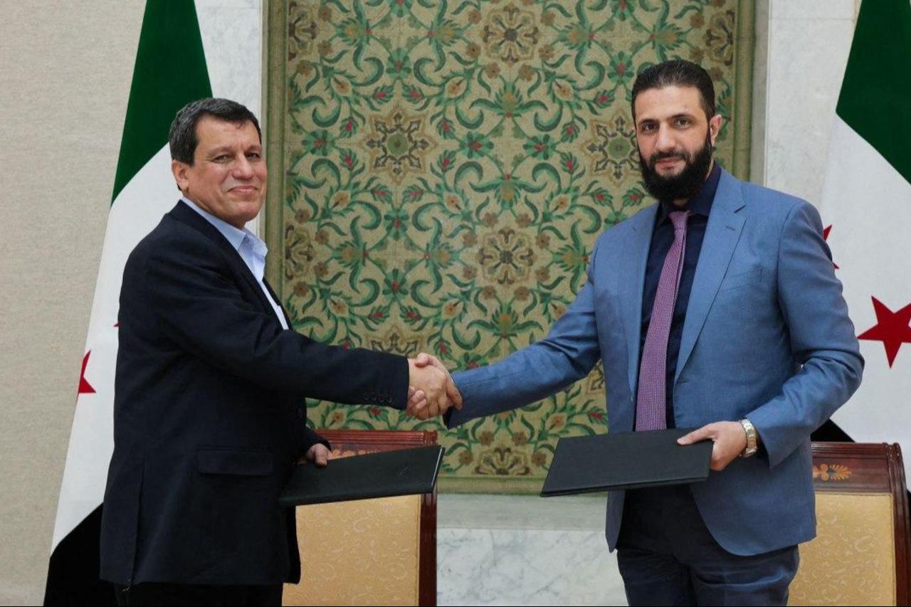 Syrias President Ahmed al-Sharaa (R) shaking the hand of YPG/SDFs so-called commander-in-chief Ferhat Abdi Sahin, also known as Mazloum Abdi after the signing of an agreement in the Syrian capital Damascus on March 10, 2025. (Photo by SANA / Handout / AFP)