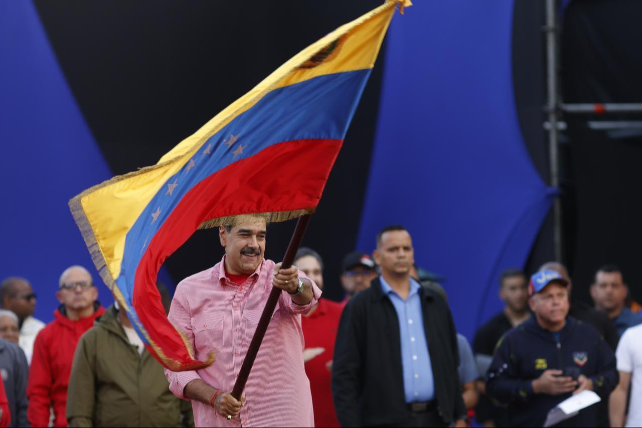 Venezuelan President Nicolas Maduro waves a Venezuelan flag during a march to swear in the Bolivarian Grassroots Committees in Caracas, Venezuela, on Nov. 15, 2025. (AA Photo)