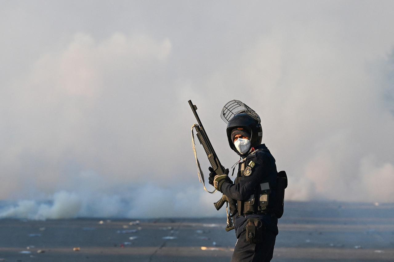 A policeman stands amid tear gas as supporters of Pakistan Tehreek-e-Insaf (PTI) party protest to demand the release of former prime minister Imran Khan, in Islamabad on Nov. 26, 2024. (AFP Photo)