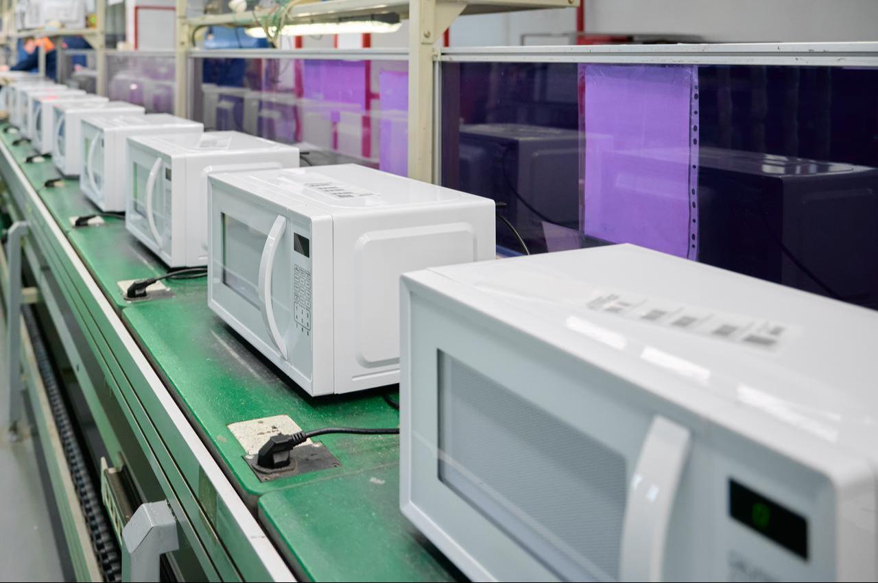 Microwave ovens on an assembly line at a manufacturing facility. (Adobe Stock Photo)