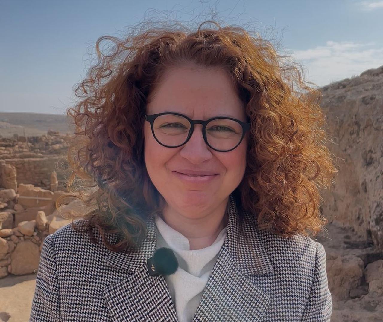 Assoc. Prof. Mucella Erdalkiran speaking to Türkiye Today during a research visit to Karahantepe, standing against the backdrop of monumental Pre-Pottery Neolithic structures uncovered as part of the Tas Tepeler Project. (Photo by Koray Erdogan/Türkiye Today)