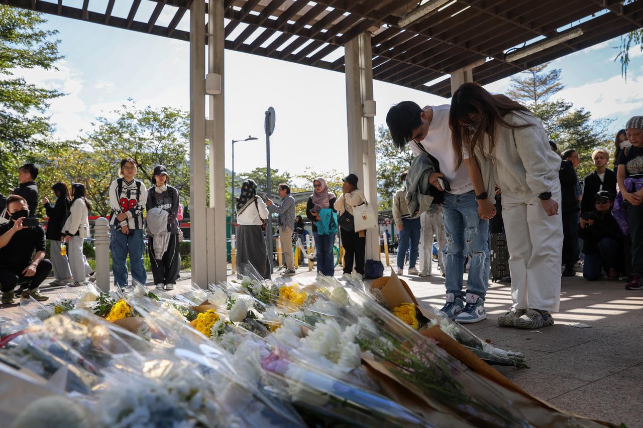 People lay flowers to pay tribute to the deceased victims of the Wang Fuk Court apartment building fire, in Tai Po, Hong Kong, on Nov. 29, 2025. (AA Photo)