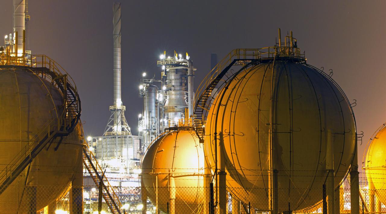 A liquefied natural gas (LNG) storage facility in an industrial refinery complex. (Adobe Stock Photo)