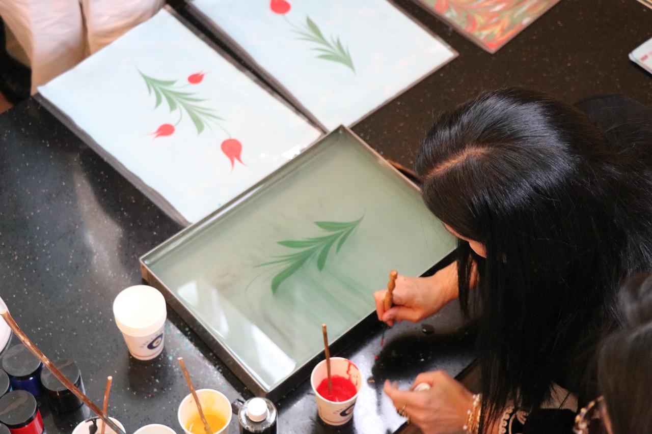 A participant practices Ebru, the traditional Turkish marbling art, during a live demonstration at Peking University’s Turkish Cuisine Week, Beijing, China, Nov. 3, 2025. (AA Photo)