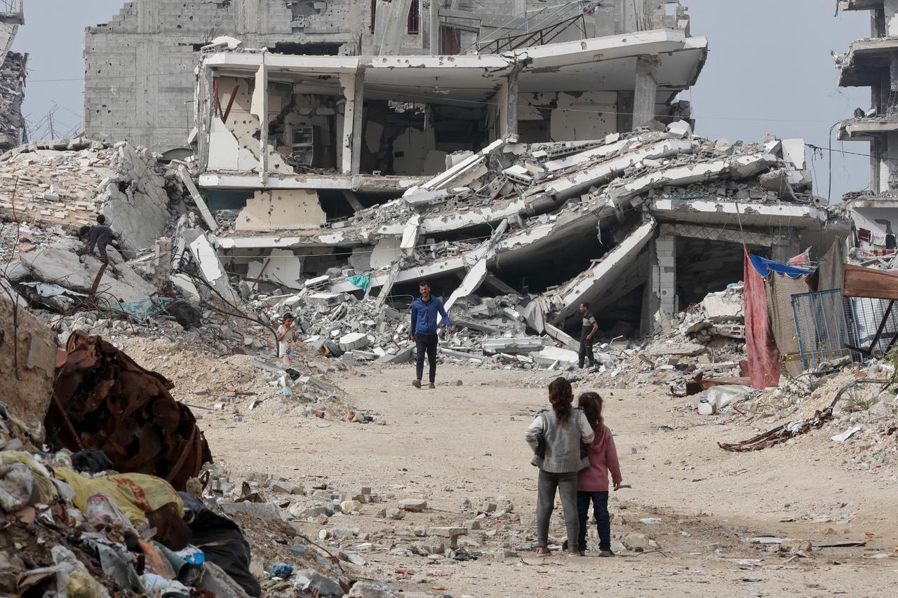 Displaced Palestinians walk past destroyed buildings in the Tel al-Hawa neighborhood, in the southern part of Gaza City,  November 29, 2025. (AFP Photo)