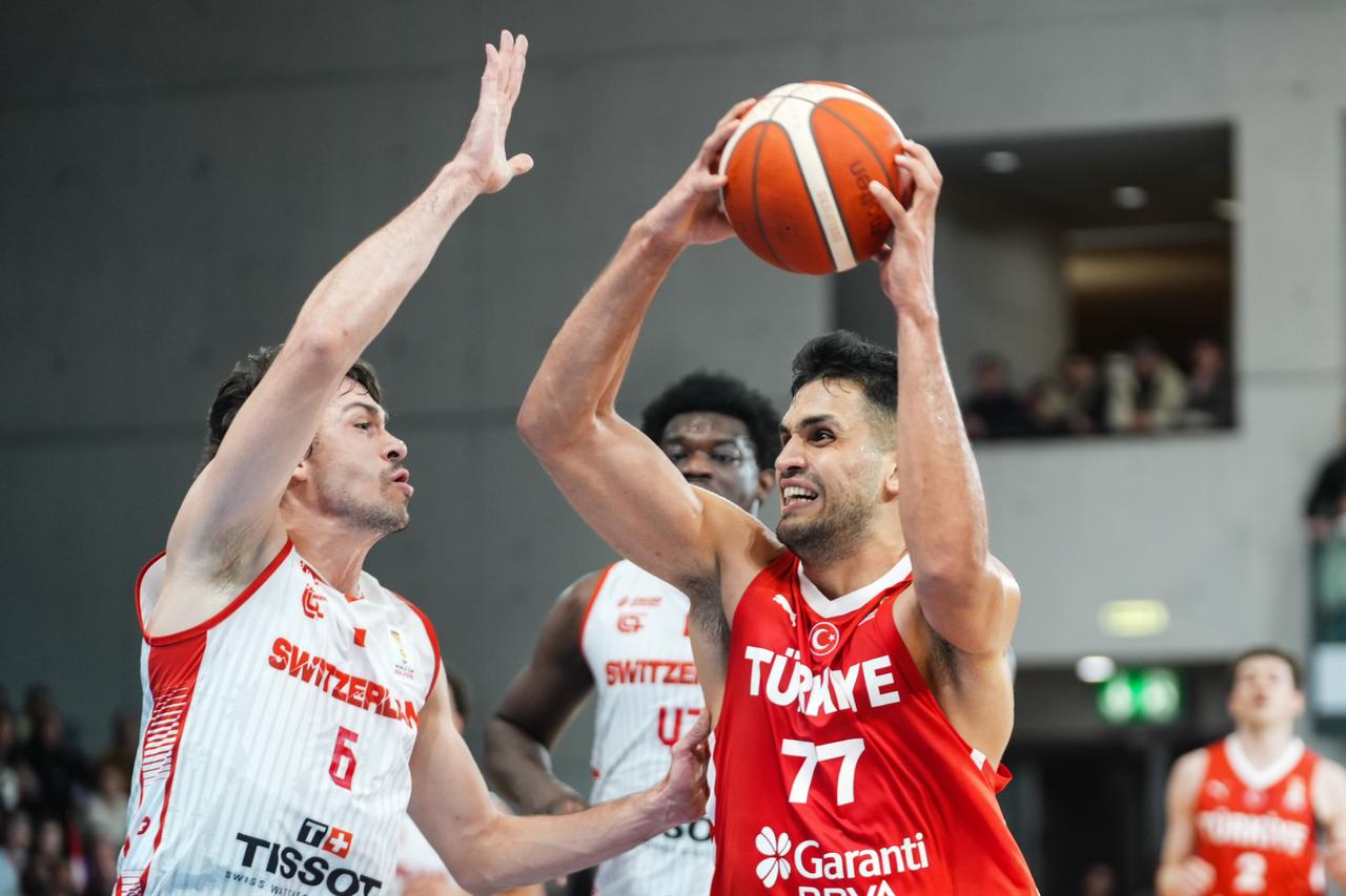 Omer Faruk Yurtseven (77) of Türkiye in action against Paul Gravet (L) of Switzerland during the FIBA 2027 World Cup European Qualifiers Group C second-round match between Switzerland and Turkiye at Saint-Leonard Sports Hall in Fribourg, Switzerland on Nov. 30, 2025.  (AA Photo)