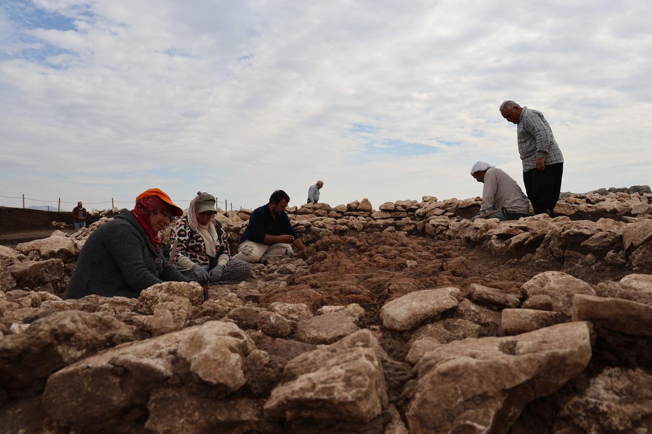 Excavation team members clean and document collapsed mudbrick layers at Cayonu Hill, where archaeologists believe an ancient quake toppled a building after its abandonment. (IHA Photo)