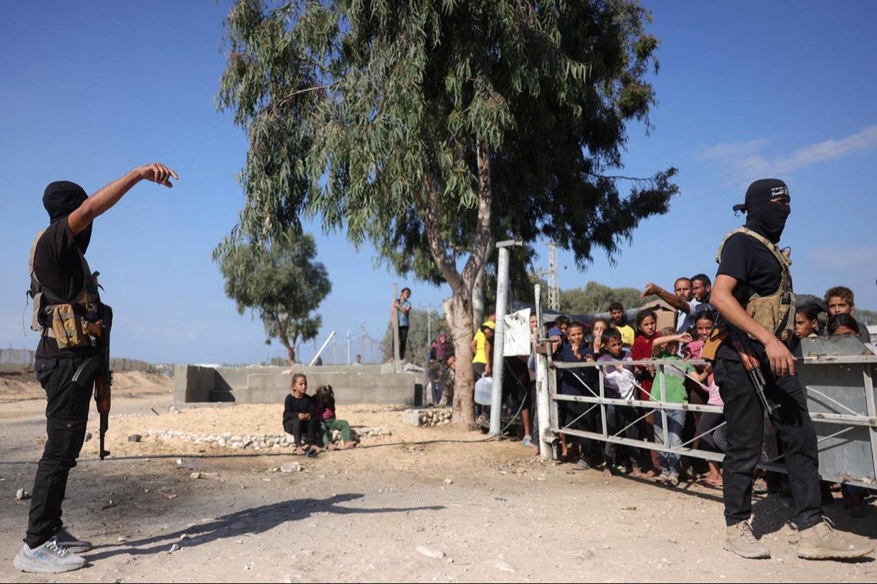 Palestinian militants wearing bandanas showing the name of Izzedine al-Qassam Brigades, armed wing of Hamas, stand guard before arrival of ICRC vehicles in central Gaza Strip, Oct. 13, 2025. (AFP Photo)