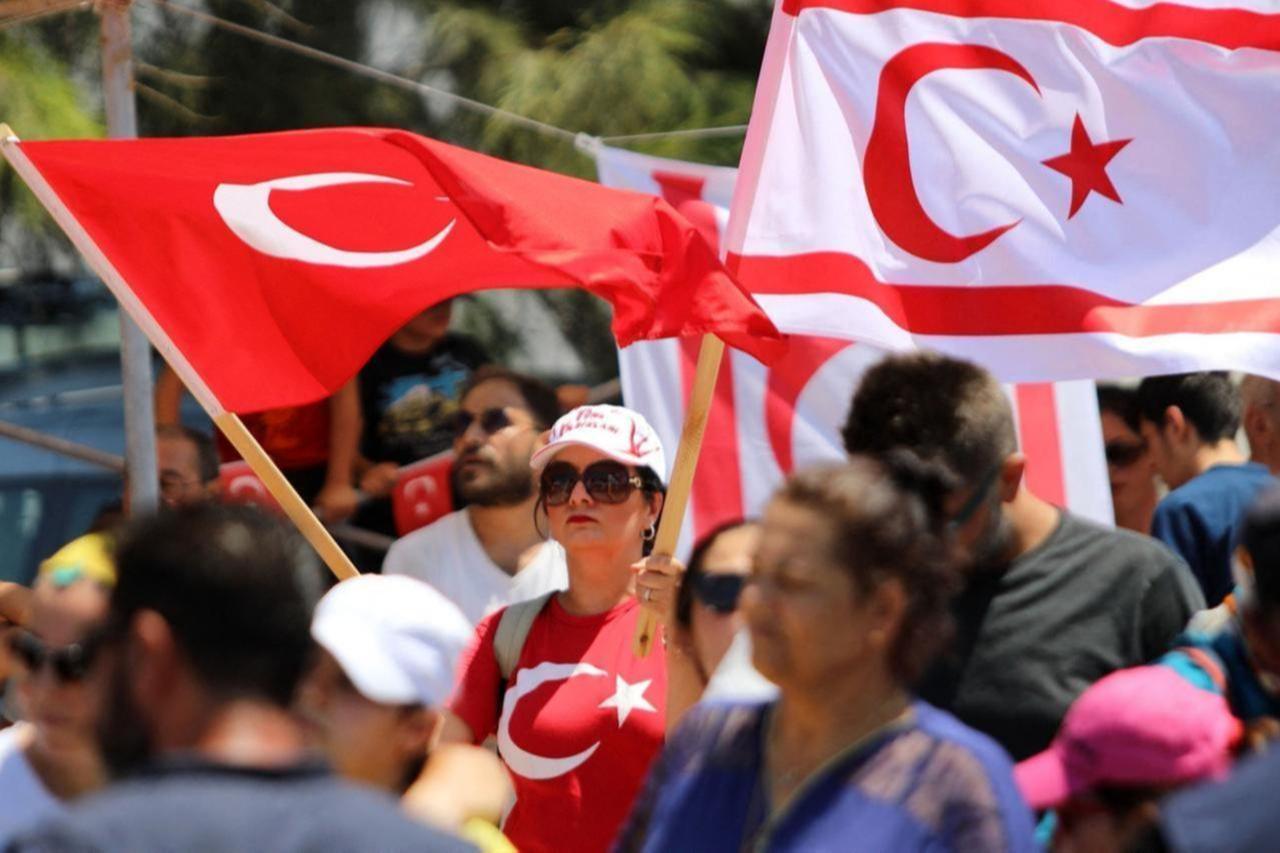 People wave Turkish Cypriot (R) and Turkish flags during a military parade on the anniversary of Türkiyes Peace Operation, Lefkosia (Nicosia), Turkish Cyprus, July 20, 2024. (AFP Photo)