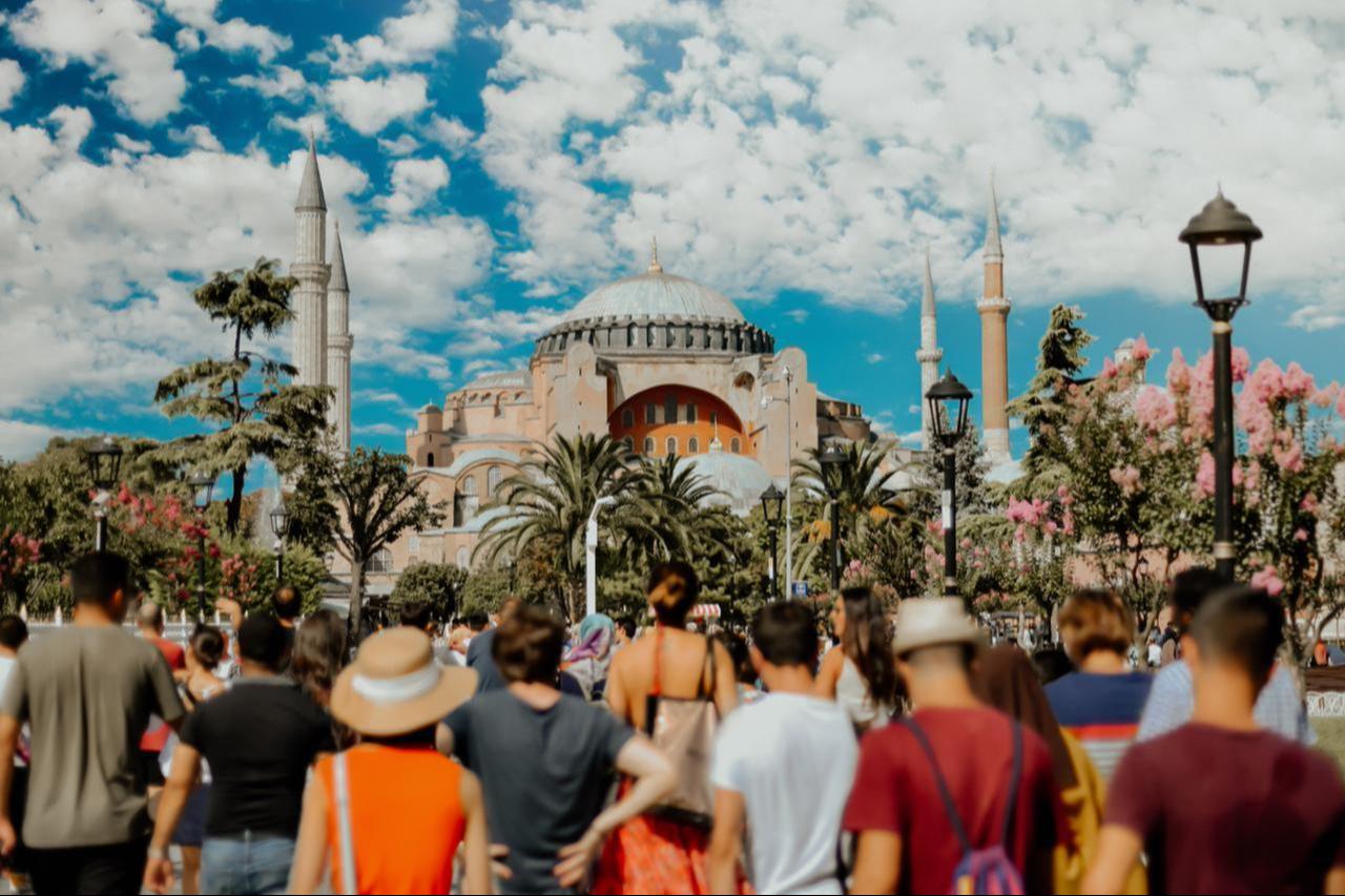 Crowds of visitors walk toward the Hagia Sophia in Istanbul, Türkiye, on a bright summer day. (Adobe Stock Photo)