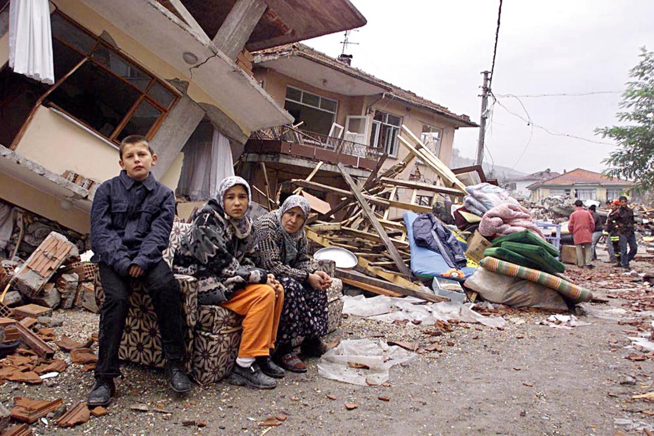 Residents sit on the debris of their house in Türkiye’s Kaynasli on Nov. 17, 1999, following an earthquake. (AFP Photo)