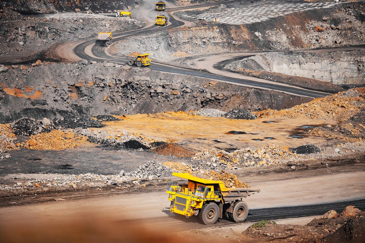 Heavy haul trucks transport ore at an open-pit mining site, illustrating large-scale extraction and logistics. (Adobe Stock Photo)