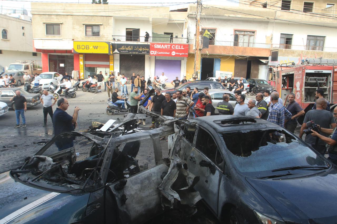 People gather at the site of an Israeli drone strike that targeted a vehicle in the southern Lebanese village of Doueir near the city of Nabatiyeh, on November 3, 2025. (AFP Photo)